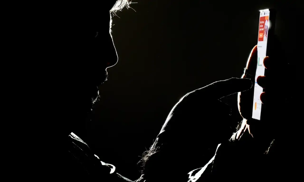 Silhueta de homem segura celular mostrando bet