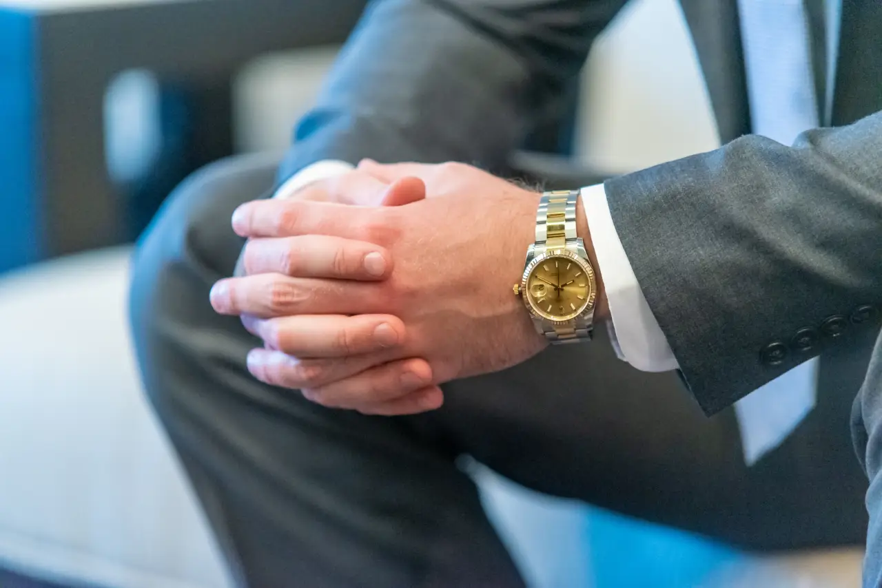 man-suit-clasping-his-hands-using-Rolex