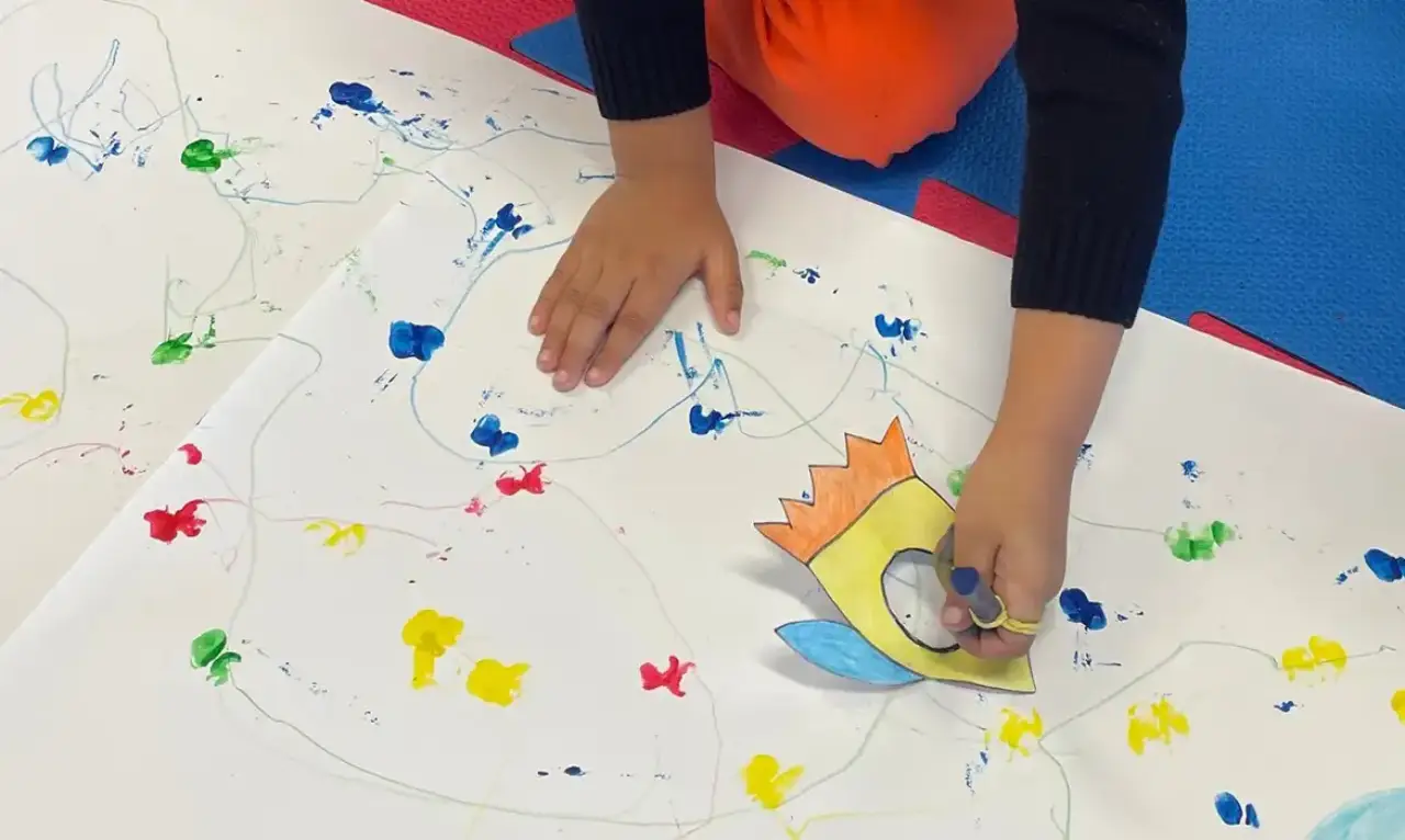 Mãos de criança desenham sobre papel