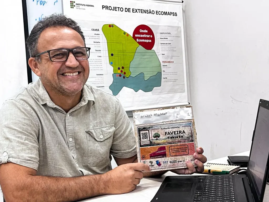 Prof. João Abreu no laboratório de informática do IFCE Crato, segurando placa que será inserida em uma trilha inclusiva