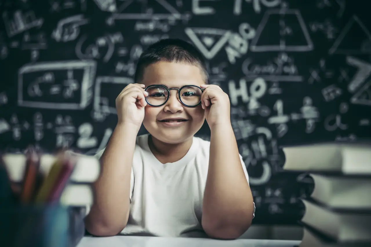 menino-estudando-e-segurando-a-perna-de-oculos-em-sala-de-aula