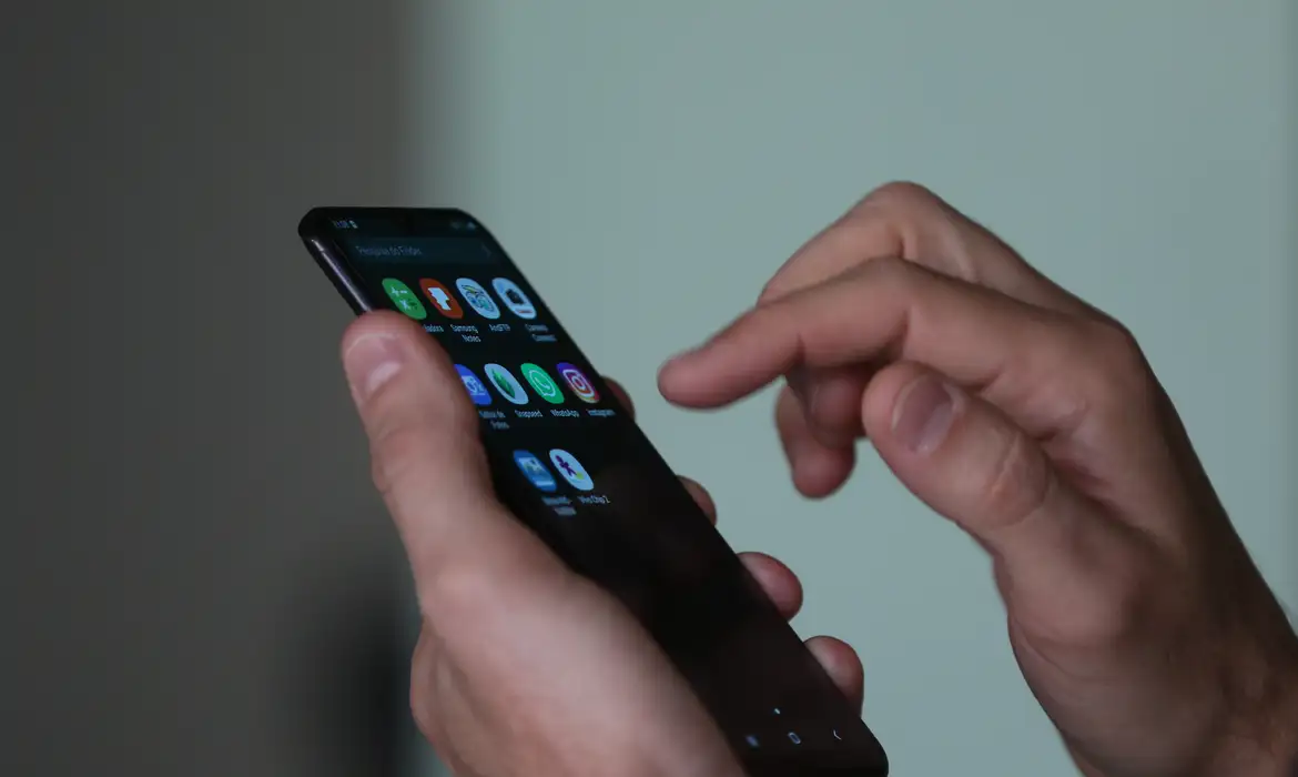 Mão digitando em smartphone