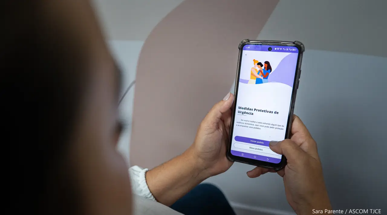Mulher acessa celular com o app TJCE Mobile