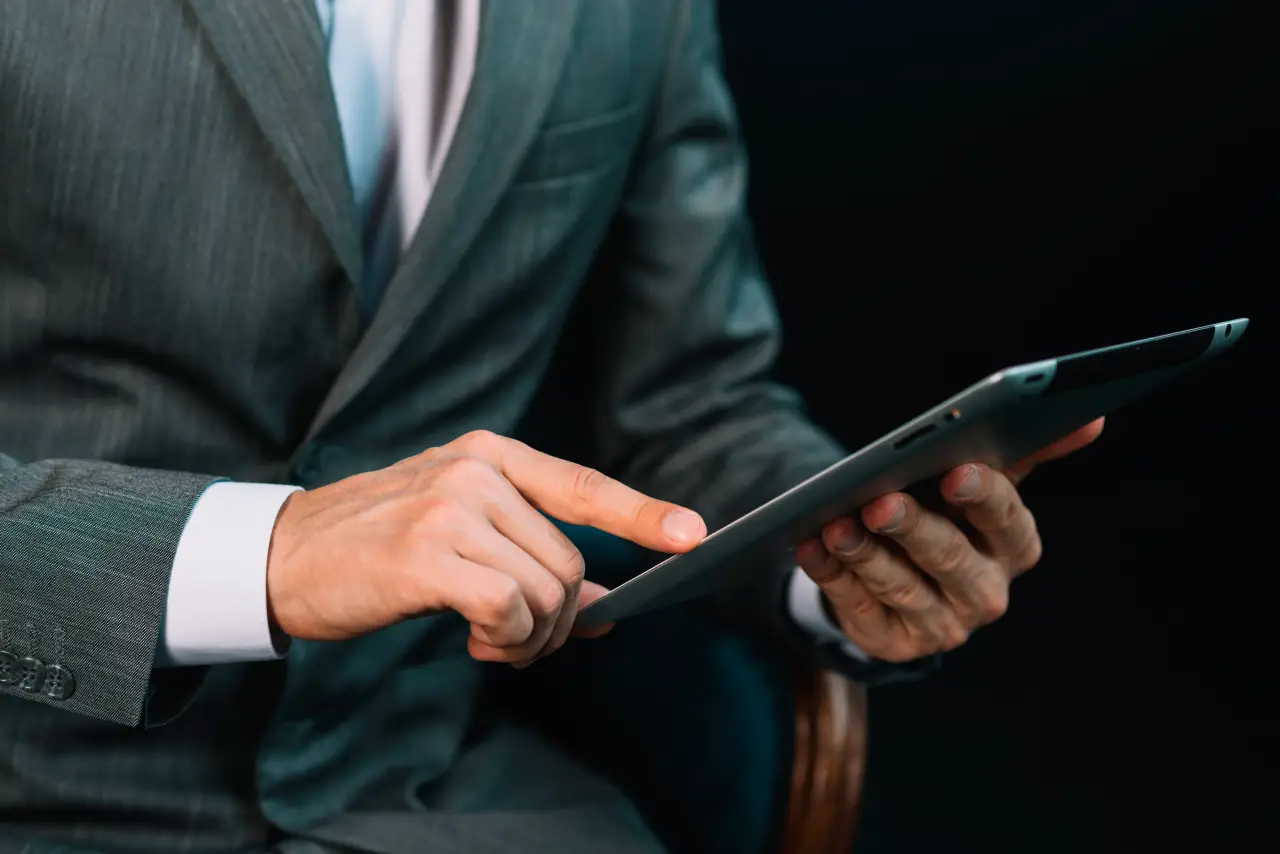 Close-up de homem de negoócios com mão tocando tela de tablet